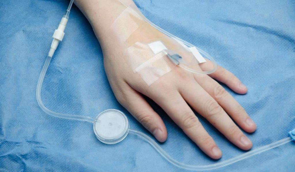 Nurse starting an intravenous immunoglobulin infusion through a peripheral IV line